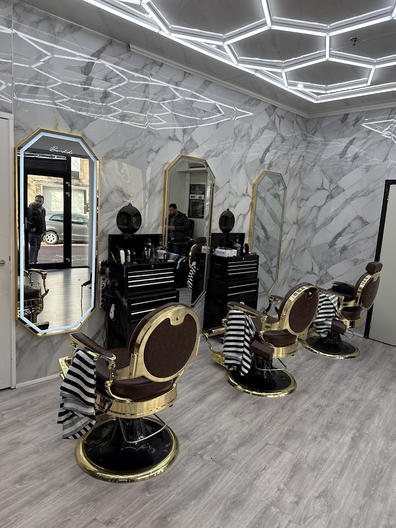 Interieur van Barbershop Roosendaal met marmeren wand en gouden barberstoelen